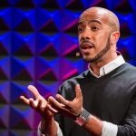 Thisis the image of Clint Smith wearing black T-shirt and giving speech about danger of silence