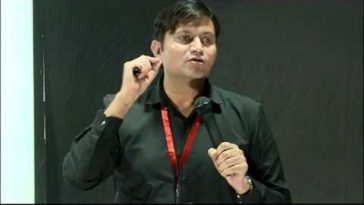 this is the image of krishan Chahal giving speech at TED event. He is wearing black shirt