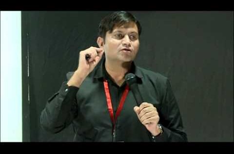 this is the image of krishan Chahal giving speech at TED event. He is wearing black shirt