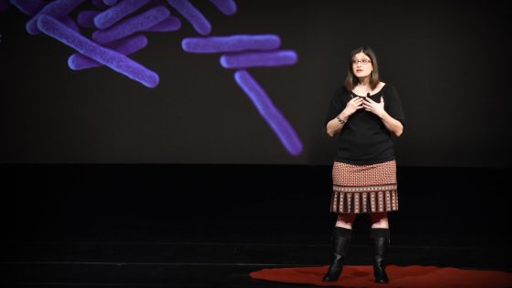 It is the image of Lara Durgavich who is a TED speaker and giving speech on Evoulution of Humans